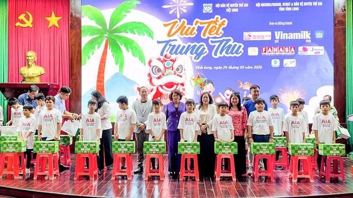 Đồng chí Đặng Thị Ngọc Thịnh, nguyên Ủy viên Trung ương Đảng, nguyên Phó Chủ tịch nước cùng nhà tài trợ trao quà cho các em thiếu nhi. (Ảnh: BÁ DŨNG)