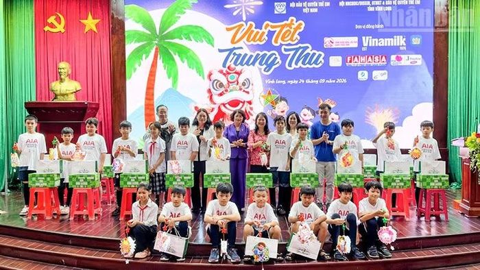 Đồng chí Đặng Thị Ngọc Thịnh, nguyên Ủy viên Trung ương Đảng, nguyên Phó Chủ tịch nước cùng nhà tài trợ trao quà cho các em thiếu nhi. (Ảnh: BÁ DŨNG)