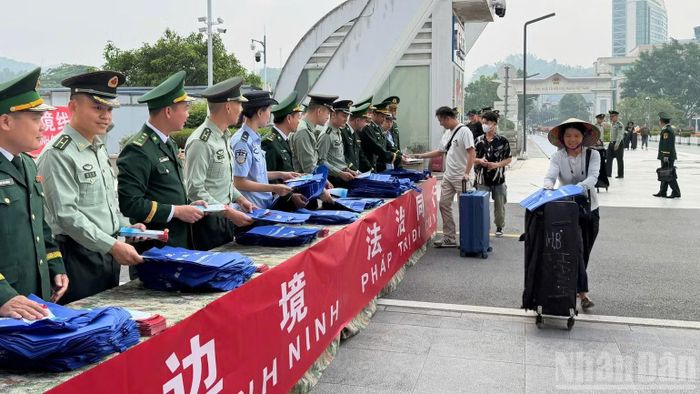 Lực lượng Biên phòng hai bên phối hợp tuyên truyền pháp luật cho hành khách và cư dân biên giới. (Ảnh: Bộ đội Biên phòng tỉnh Lào Cai)