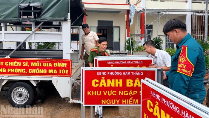 Lực lượng chức năng vận chuyển biển cảnh báo đến các điểm ngập. (Ảnh: THANH HẢI)