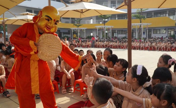 Các em học sinh thích thú hô “Yeah!” và giao lưu cùng ông Địa trong ngày hội Trung thu. (Ảnh: MINH TÂM)