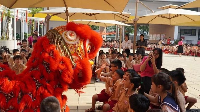 Học sinh Trường tiểu học Bùi Quốc Khái thích thú với giao lưu cùng đội múa lân. (Ảnh: MINH TÂM)