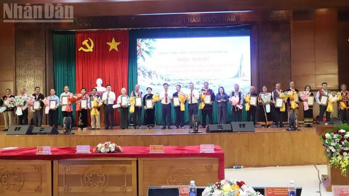 Lãnh đạo tỉnh Đắk Lắk trao giấy chứng nhận và tặng hoa chúc mừng các già làng, người có uy tín tiêu biểu. (Ảnh: CÔNG LÝ)