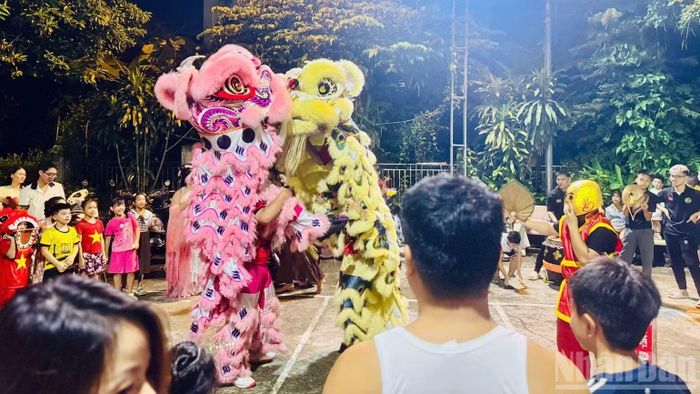 Hoạt động múa lân truyền thống bên ngoài khu dân cư thu hút sự theo dõi của đông đảo người dân. (Ảnh: HNV)