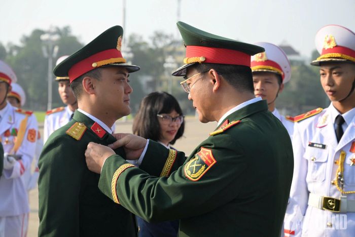  Thiếu tướng Nguyễn Việt Dũng và chỉ huy Cục Pháp chế Bộ Quốc phòng gắn Huy hiệu Bác Hồ tặng các đại biểu.