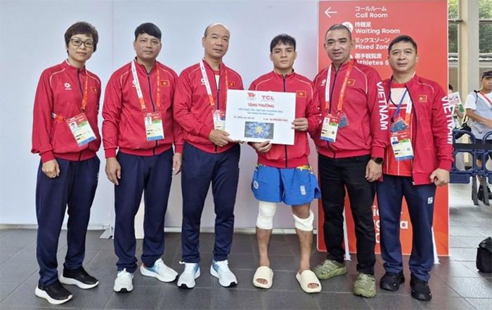 Võ sĩ Đinh Văn Tâm được thưởng nóng sau khi giành HCB trong trận chung kết tán thủ hạng 56kg nam sáng 24-9 tại ASIAD 20. Ảnh: BÙI LƯỢNG