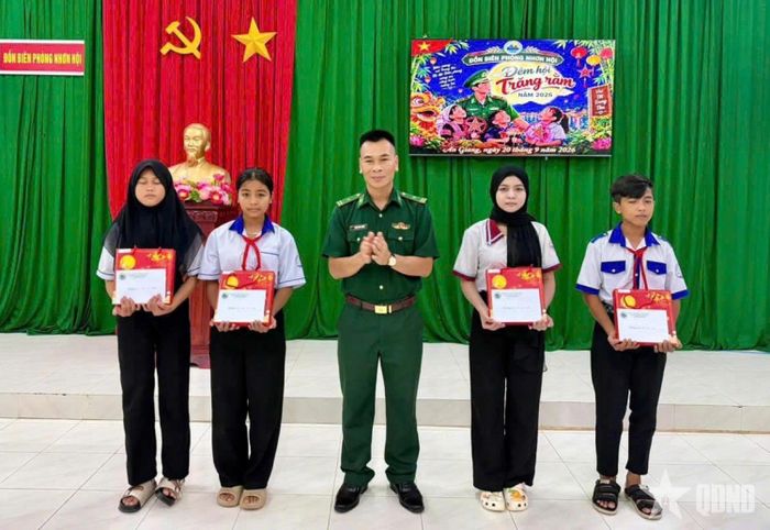 Thiếu tá Phạm Xuân Trường, Phó đồn trưởng Nghiệp vụ, Đồn Biên phòng Nhơn Hội tặng quà cho các cháu học sinh trong chương trình "Nâng bước em tới trường - Con nuôi biên phòng".