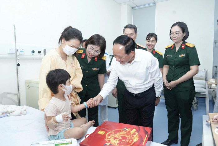 Trưởng Ban Tuyên giáo Trung ương Trịnh Văn Quyết trò chuyện, tặng quà các bệnh nhi tại Bệnh viện Quân y 103. Ảnh: PHẠM HÙNG
