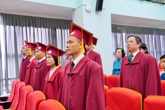 Các tân tiến sĩ cùng các đại biểu tiến hành nghi thức chào cờ.