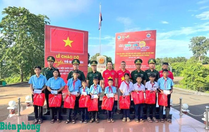 Cán bộ Đồn Biên phòng cửa khẩu quốc tế Lệ Thanh, Bộ đội Biên phòng tỉnh Gia Lai và đại diện Nhóm G9 “Vì nụ cười trẻ thơ” thuộc Hội Liên hiệp Thanh niên Việt Nam thành phố Hồ Chí Minh trao quà cho các em được đỡ đầu trong Chương trình “Nâng bước em tới trường - Con nuôi đồn Biên phòng”. Ảnh: Thanh Bình
