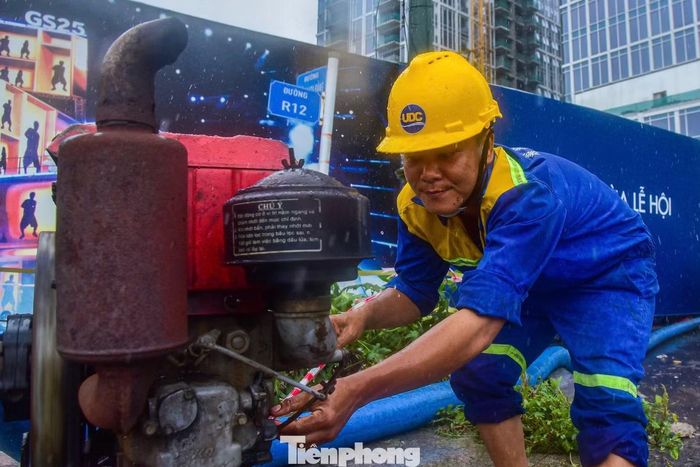 Các công nhân phải làm việc dưới trời mưa nhằm nhanh chóng giải tỏa nước trên mặt đường.