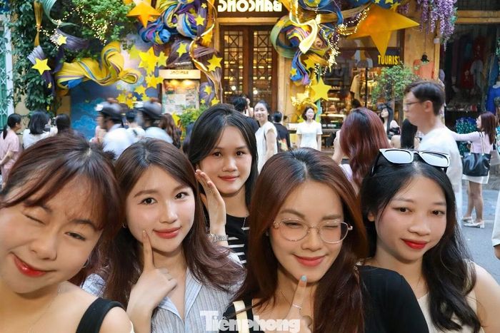 Nhiều bạn trẻ xếp hàng chờ chụp ảnh trước photobooth của một quán cà phê ở góc phố Đinh Liệt - Hàng Bạc.