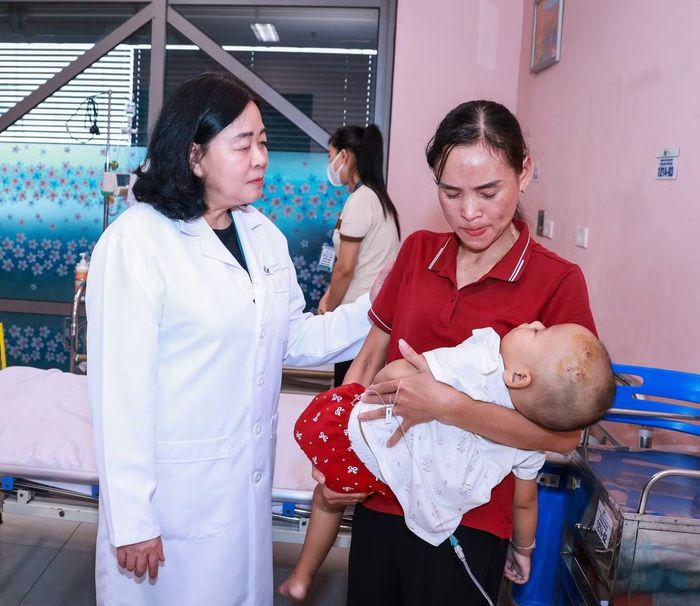  Bà Bùi Thị Minh Hoài động viên, chia sẻ với gia đình bệnh nhi. Ảnh: H.D. 