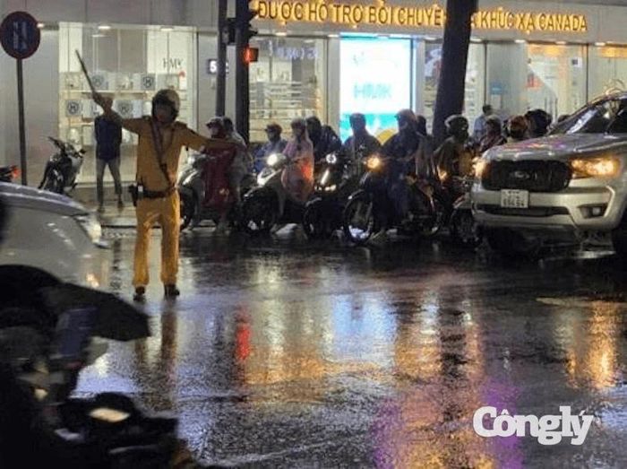 CSGT điều tiết, phân luồng giao thông, giúp người dân lưu thông an toàn trong mưa.
