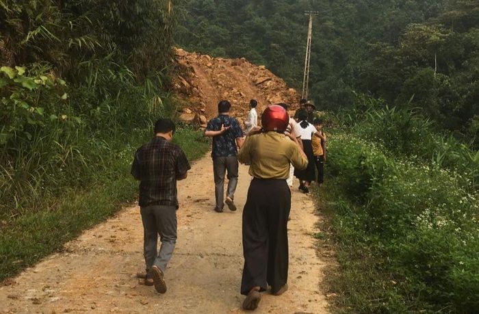 Các lực lượng và giáo viên trường THCS Tân Hợp hỗ trợ học sinh đi bộ qua điểm sạt lở vào sáng sớm. Ảnh: Đức Mậu