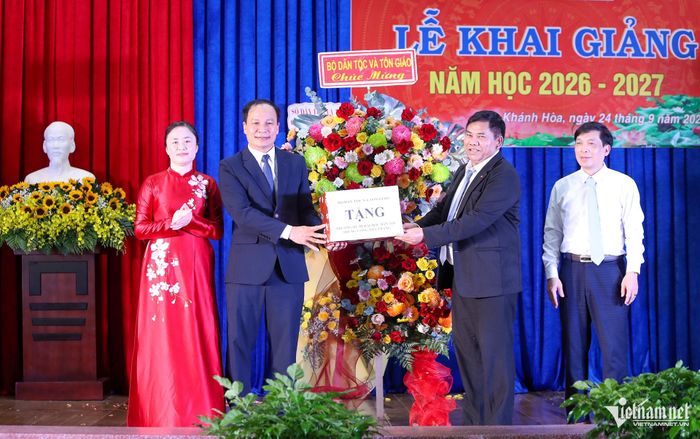 Thứ trưởng Y Thông trao tặng hoa chúc mừng khai giảng năm học mới cho nhà trường. Ảnh: Xuân Ngọc