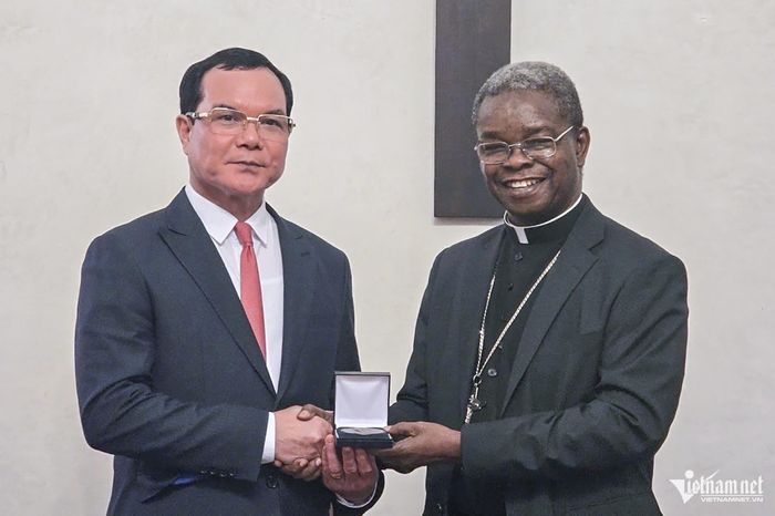 Tổng Giám mục Fortunatus Nwachukwu, Tổng Thư ký Bộ phận Truyền giáo đầu tiên và các Giáo hội địa phương - Tòa thánh Vatican tặng quà Bộ trưởng Bộ Dân tộc và Tôn giáo Việt Nam Nguyễn Đình Khang.