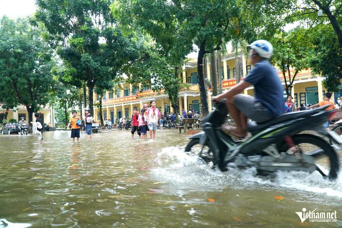 Phụ huynh đi xe máy vào trong sân trường đón con. Ảnh: Lê Dương
