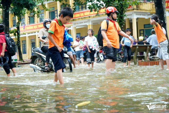 Nhiều học sinh lội, nghịch nước trong sân trường. Ảnh: Lê Dương