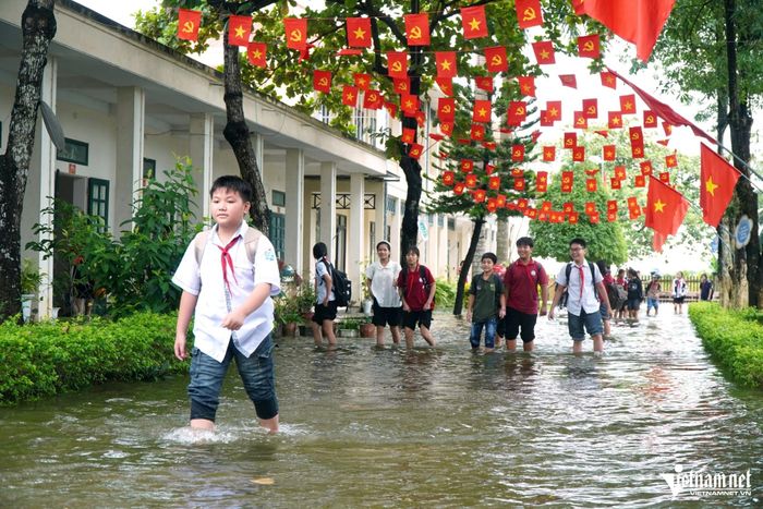 Học sinh lội nước bì bõm trong sân trường. Ảnh: Lê Dương