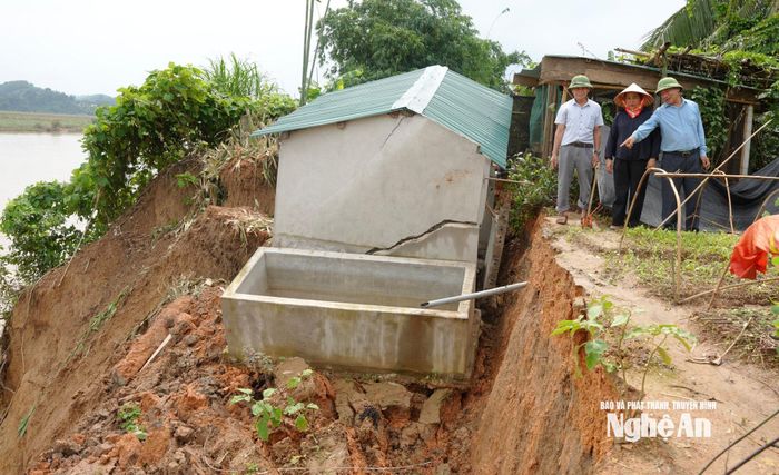 Chuồng chăn nuôi và bể nước của gia đình chị Võ Thị Phong bị nứt toác, chực chờ sập xuống sông do sạt lở đất. Ảnh: Quang Minh