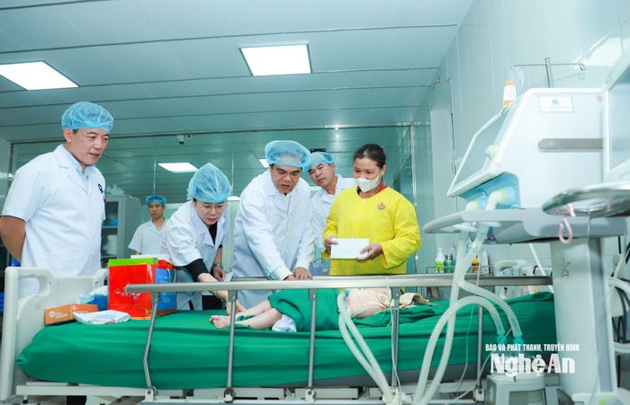 Chủ tịch UBND tỉnh và đoàn công tác thăm hỏi công tác điều trị với một bệnh nhi nặng. Ảnh: Thành Duy