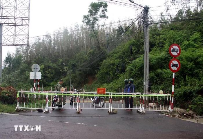 Lực lượng chức năng đặt rào chắn, cảnh báo không cho người và phương tiện lưu thông qua dốc Mộng Cầm. (Ảnh: Trịnh Bang Nhiệm/TTXVN)