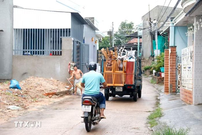Các hộ dân ven sông Cái (phường Hàm Thắng, tỉnh Lâm Đồng) di dời tài sản đến nơi khác để tránh lũ. (Ảnh: Nguyễn Thanh/TTXVN)