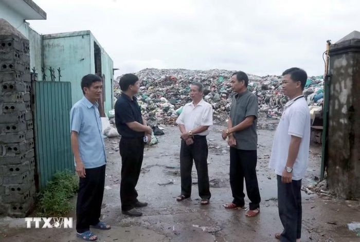 Lãnh đạo xã Thư Vũ, tỉnh Hưng Yên, cùng người dân thị sát khu vực bãi rác quá tải với lượng tồn đọng lên tới 30.000 tấn, ảnh hưởng trực tiếp đến đời sống sinh hoạt của các hộ dân xung quanh. (Ảnh: Đinh Văn Nhiều/TTXVN)