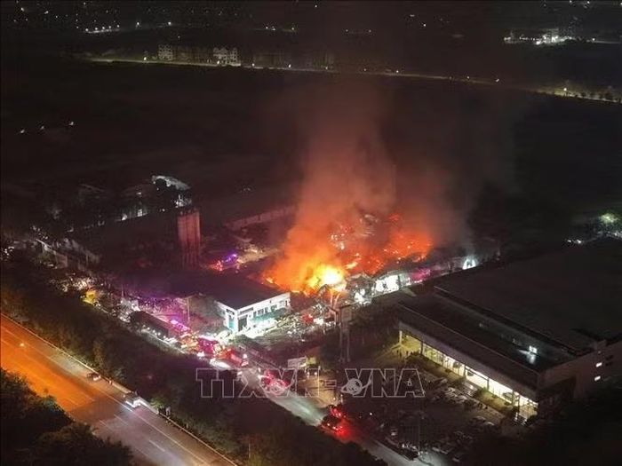 Đến gần 12h, ngọn lửa kèm khói đen vẫn bốc cao, lực lượng chức năng vẫn đang cố gắng dập lửa. Ảnh: Phạm Tuấn Anh/TTXVN