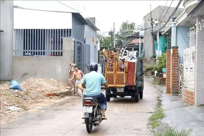 Các hộ dân ven sông Cái (phường Hàm Thắng, tỉnh Lâm Đồng) di dời tài sản đến nơi khác để tránh lũ. Ảnh: Nguyễn Thanh /TTXVN.