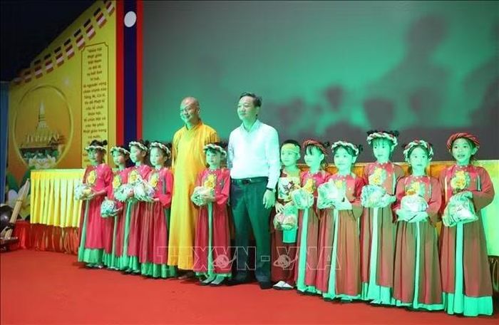 Đại sứ Việt Nam tại Lào Nguyễn Minh Tâm và Thượng tọa Thích Minh Quang trao tặng những phần quà cho các cháu thiếu nhi tại sự kiện. Ảnh: Xuân Tú/ PV TTXVN tại Lào