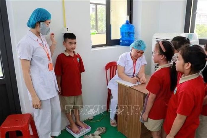 Đo cân nặng, chiều cao cho học sinh trường Tiểu học Chu Văn An, phường Nam Định (Ninh Bình).