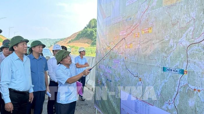 Lãnh đạo Ban Quản lý dự án đầu tư xây dựng công trình số 1 tỉnh Tuyên Quang giới thiệu với Bộ trưởng Bộ Xây dựng Trần Hồng Minh tiến độ của dự án. Ảnh: Hoàng Hải - TTXVN 