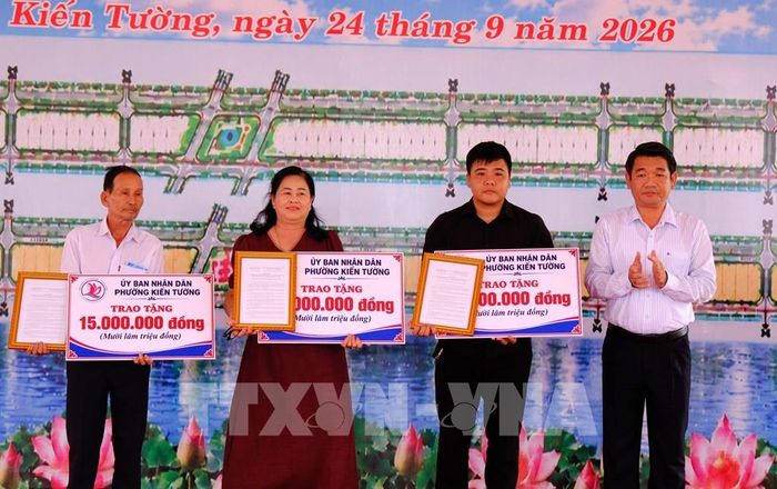 Lãnh đạo phường Kiến Tường khen thưởng các hộ dân có nhiều đóng góp, đồng thuận trong công tác giải phóng mặt bằng thực hiện Dự án đường Tân An - Bình Hiệp. Ảnh: Bùi Giang - TTXVN 