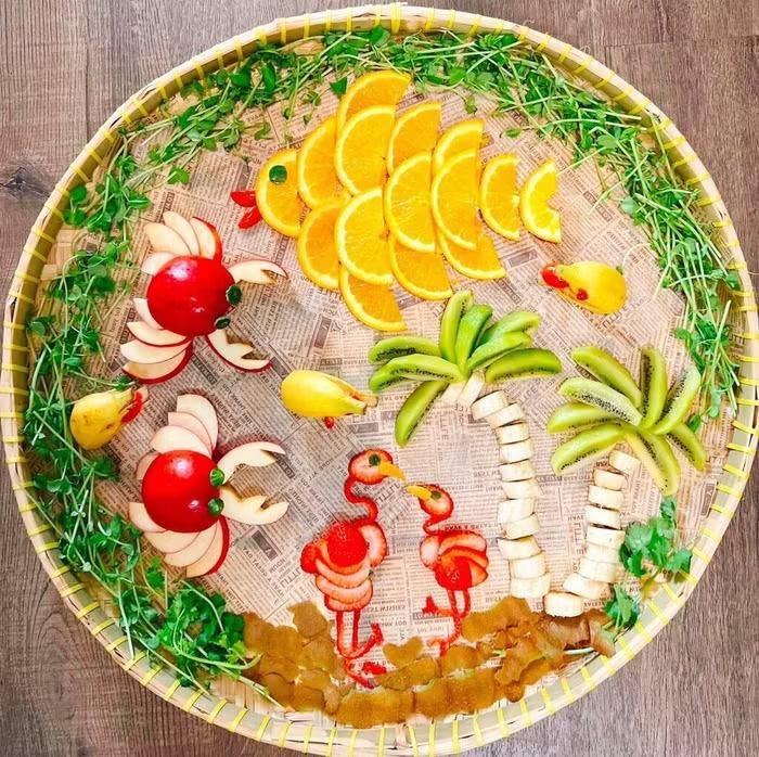 Mâm cỗ Trung thu mang chủ đề “Đảo xanh” của chị Emma Nguyễn gây ấn tượng với cách tạo hình độc đáo từ các loại hoa quả quen thuộc. Những chú cua làm từ táo đỏ, cá heo từ chuối, chim hồng hạc từ dâu tây, cùng cây dừa từ chuối và kiwi, cá từ cam vàng được sắp đặt sinh động, tạo nên một “thiên đường” thu nhỏ