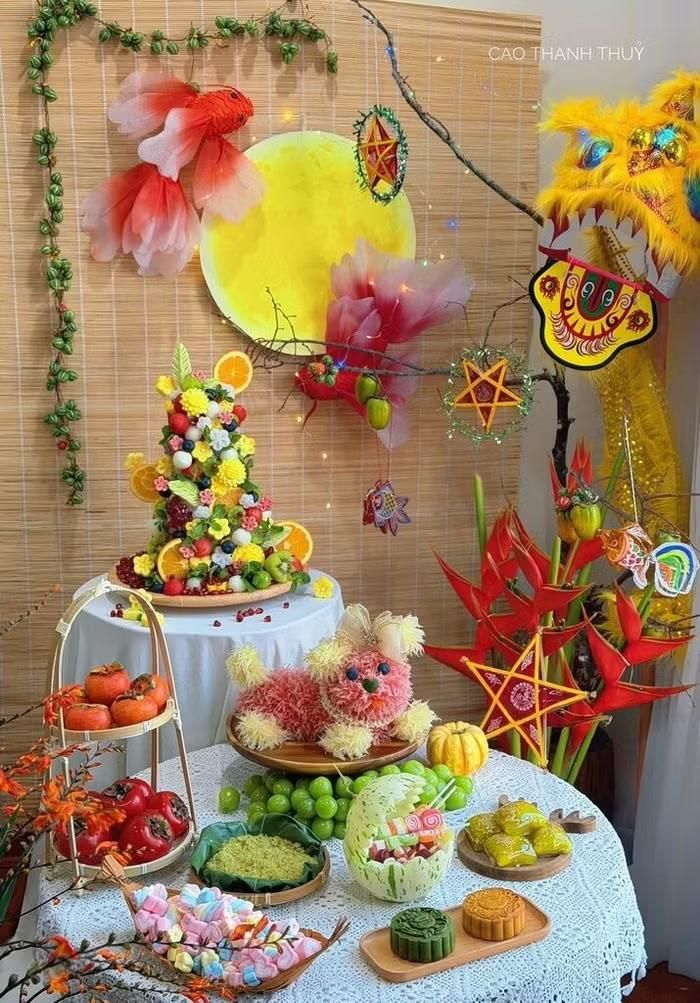 Mâm cỗ Trung thu của chị Cao Thanh Thủy tuy nhỏ nhưng được chuẩn bị công phu với chó bưởi, tháp trái cây, hồng, bánh Trung thu và nhiều loại kẹo dẻo nhiều màu sắc. Để hoàn thiện mâm cỗ, chị dành gần một ngày đi chợ, tỉa hoa quả và sắp đặt từng chi tiết. Dù mất nhiều thời gian và khá vất vả, người mẹ vẫn vui vì có thể tự tay chuẩn bị một mâm cỗ đầy màu sắc để con thỏa thích phá cỗ, tận hưởng không khí Trung thu