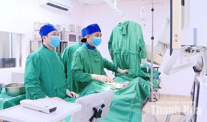 Bác sĩ Lê Xuân Chính (bên phải) thực hiện can thiệp mạch điều trị tại phòng can thiệp mạch DSA.