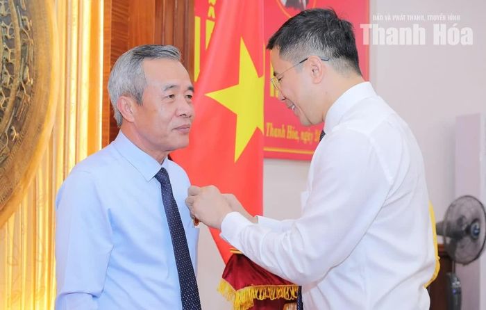 Phó Bí thư Thường trực Tỉnh ủy Nguyễn Hồng Phong gắn Huy hiệu 35 năm tuổi Đảng lên ngực áo Bí thư Tỉnh ủy Lê Đức Thái.