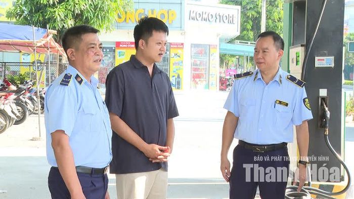 Cán bộ Đội Quản lý thị trường số 10 tuyên truyền cho hộ kinh doanh về lợi ích của thanh toán không dùng tiền mặt.