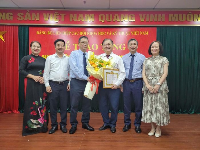 GS.VS Châu Văn Minh, Phó Chủ tịch không chuyên trách Ủy ban Trung ương Mặt trận Tổ quốc Việt Nam, Bí thư Đảng ủy, Chủ tịch Liên hiệp các Hội Khoa học và Kỹ thuật Việt Nam cùng Ban Thường vụ Đảng ủy Liên hiệp Hội Khoa học và Kỹ thuật Việt Nam tặng hoa chúc mừng TSKH Phan Xuân Dũng, Nguyên Chủ tịch Liên hiệp các Hội Khoa học và Kỹ thuật Việt Nam nhận Huy hiệu Đảng.