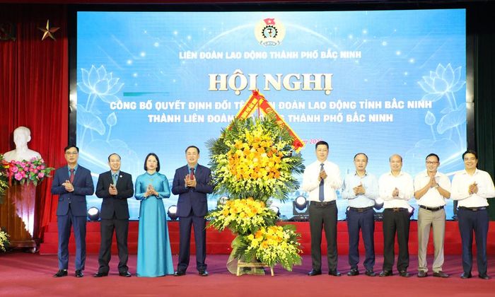  Đồng chí Trần Huy Phương (thứ năm, từ phải sang) và các đại biểu tặng hoa chúc mừng Liên đoàn Lao động thành phố Bắc Ninh. 