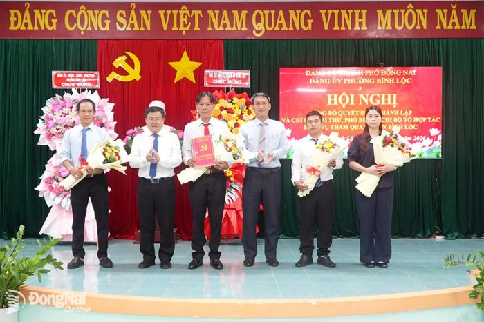 Thành ủy viên, Phó Trưởng ban Tổ chức Thành ủy, Phó Trưởng ban Thường trực Ban Chỉ đạo 07 Thành ủy Đỗ Đức Hòa (thứ 3 từ phải qua) tặng hoa chúc mừng thành lập Chi bộ Tổ hợp tác Dịch vụ tham quan vườn Bình Lộc. Ảnh: ĐVCC