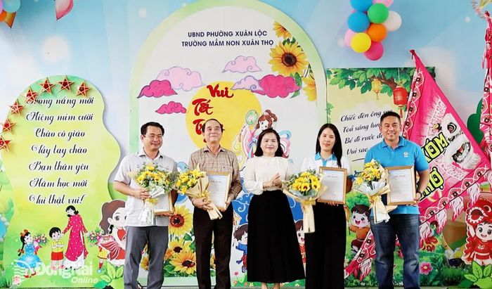 Hiệu trưởng Trường mầm non Xuân Thọ trao thư cảm ơn cho Báo và Phát thanh, Truyền hình Đồng Nai và các nhà tài trợ. Ảnh: Viết Cường