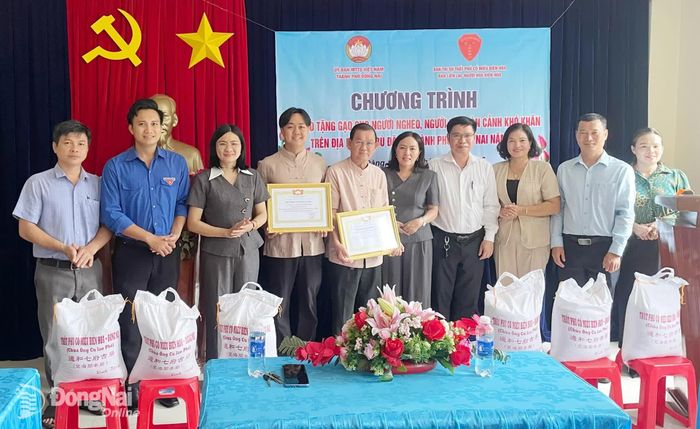 Thành viên đoàn cùng lãnh đạo địa phương tặng quà cho người dân tại xã Bù Đăng. Ảnh: Phạm Quang