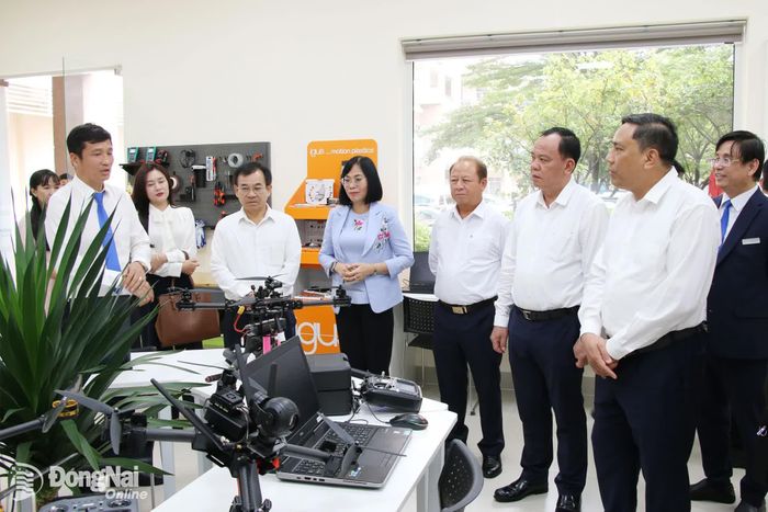 Đoàn lắng nghe đại diện Trường đại học Lạc Hồng chia sẻ các hoạt động phát triển không gian đổi mới sáng tạo, đào tạo nhân lực ngành công nghệ robotic của nhà trường. Ảnh: Hải Quân
