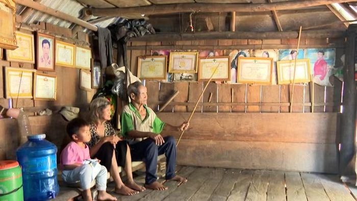 Vợ chồng ông Đinh Hnưp bên cháu ngoại trong ngôi nhà của gia đình. Ảnh: Viễn Khánh