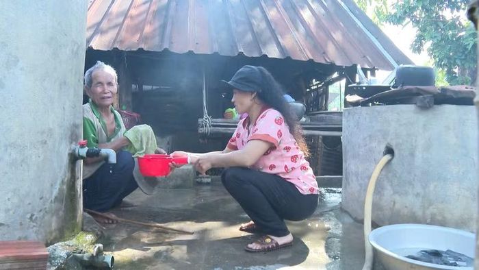 Chị Đinh Thị Trôh hằng ngày chăm sóc, giúp bố vệ sinh cá nhân. Ảnh: Viễn Khánh