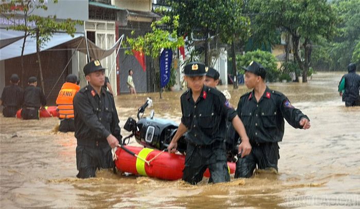 Lực lượng công an hỗ trợ người dân di chuyển tài sản đến nơi an toàn. Ảnh Mạnh Dũng