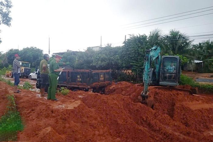 Lực lượng chức năng tập trung thu dọn bùn, cát trên mặt đường, bảo đảm phương tiện có thể lưu thông